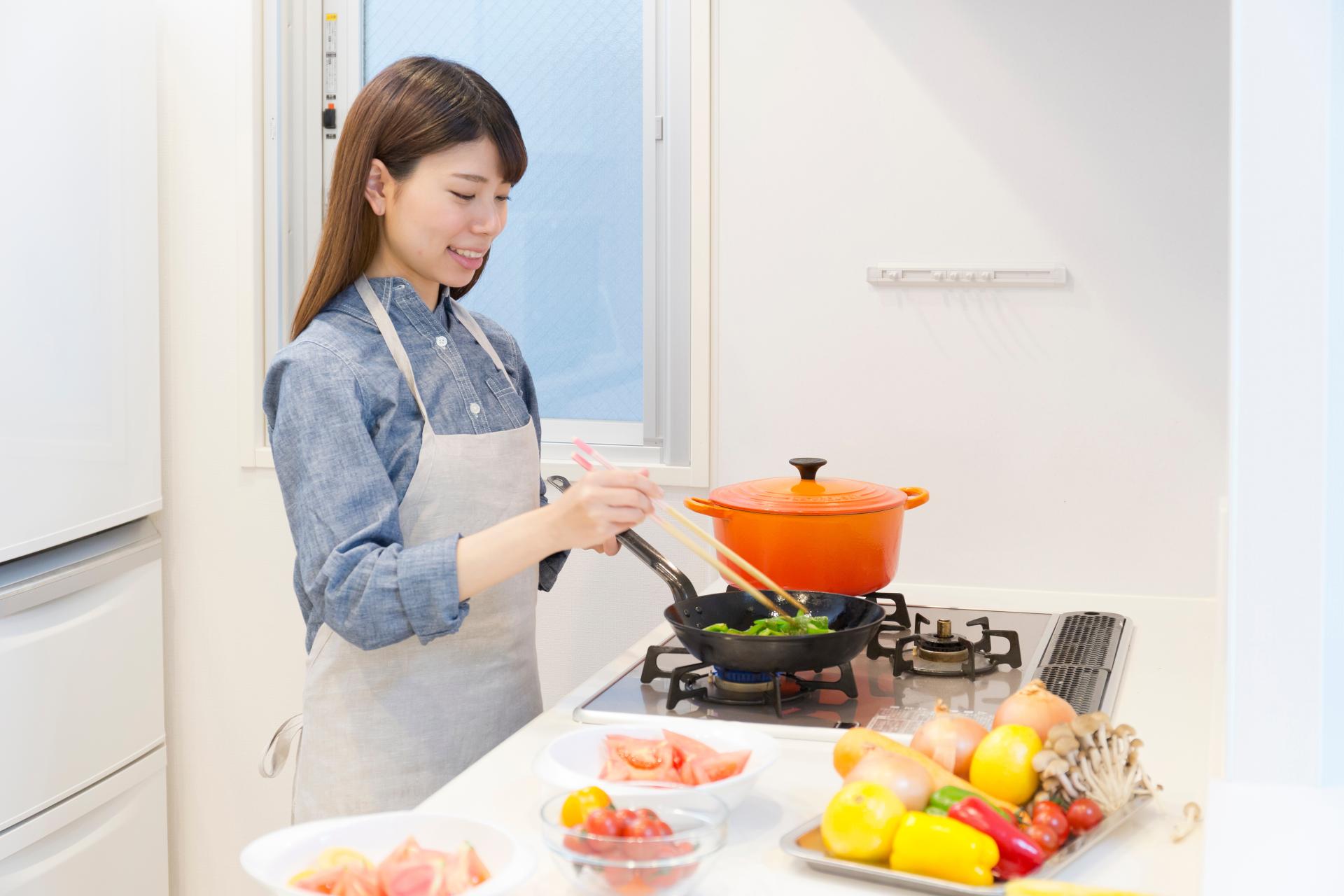 料理をする女性の画像